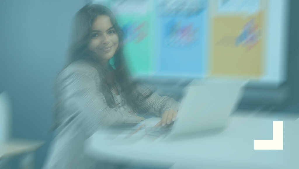 Etudiante en immobilier qui sourit assise à un bureau